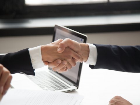 Businessman handshaking businesswoman as concept of good business deal and respect for new partner, successful partnership and great teamwork, hiring, close up view of male female hands shaking
